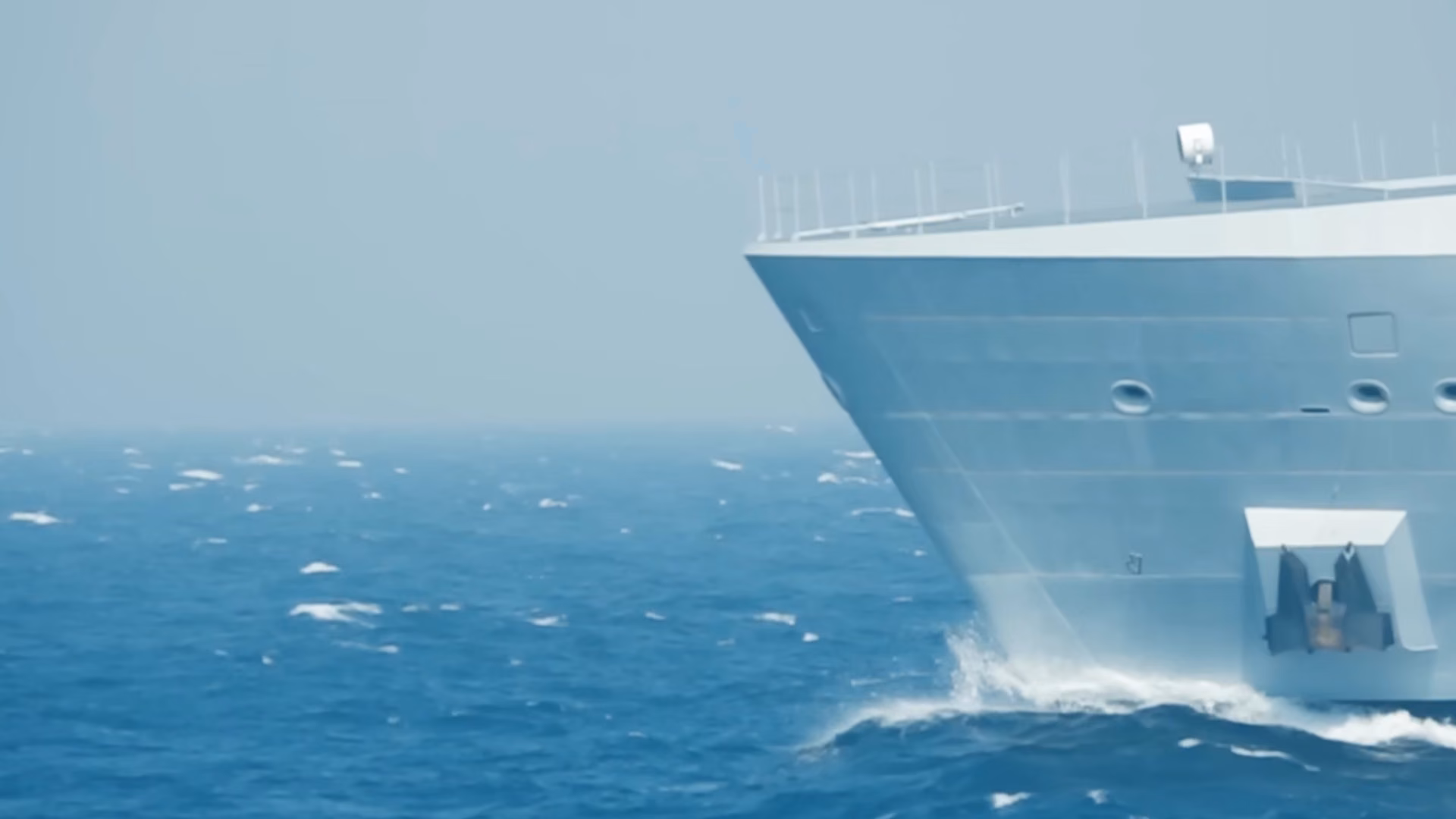 Pakistan Navy warship under way, its bow cutting through open blue sea.